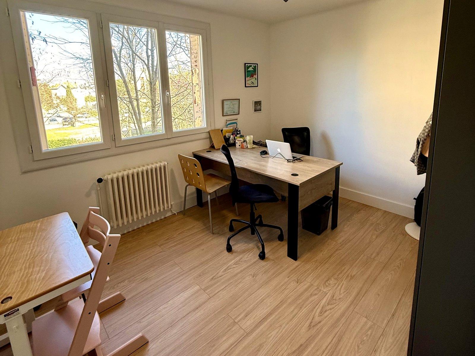 Un autre bureau du cabinet : grande fenêtre sur les arbres, table de travail et petite table avec chaise d'enfant.